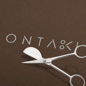 Silver scissors with 'ONTAKI' branding on a brown background